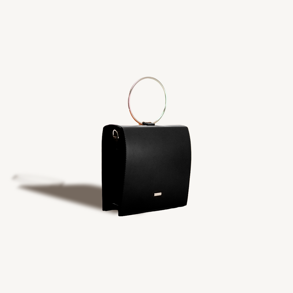 Black handbag with a circular handle on a white background