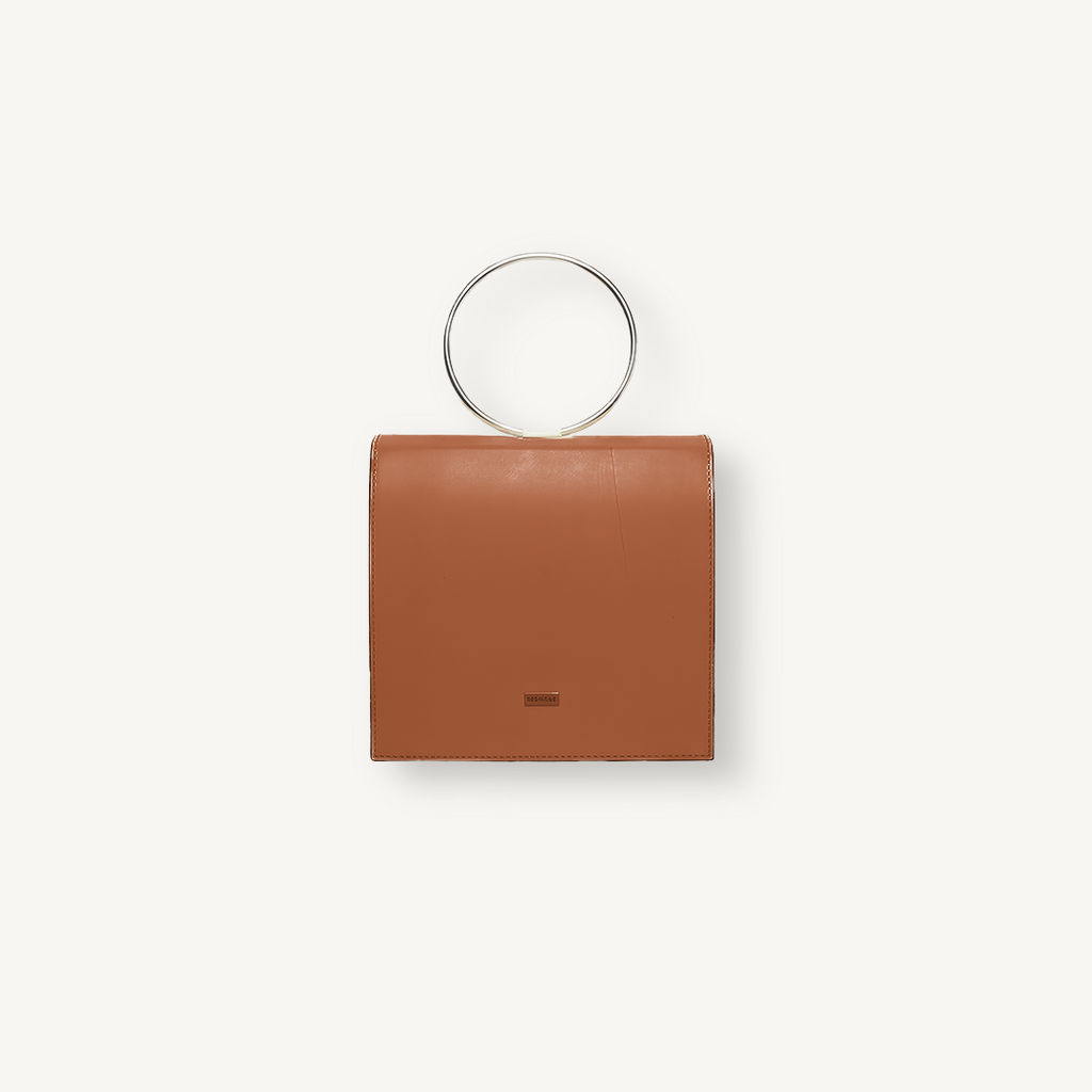 Brown handbag with circular handle on a white background