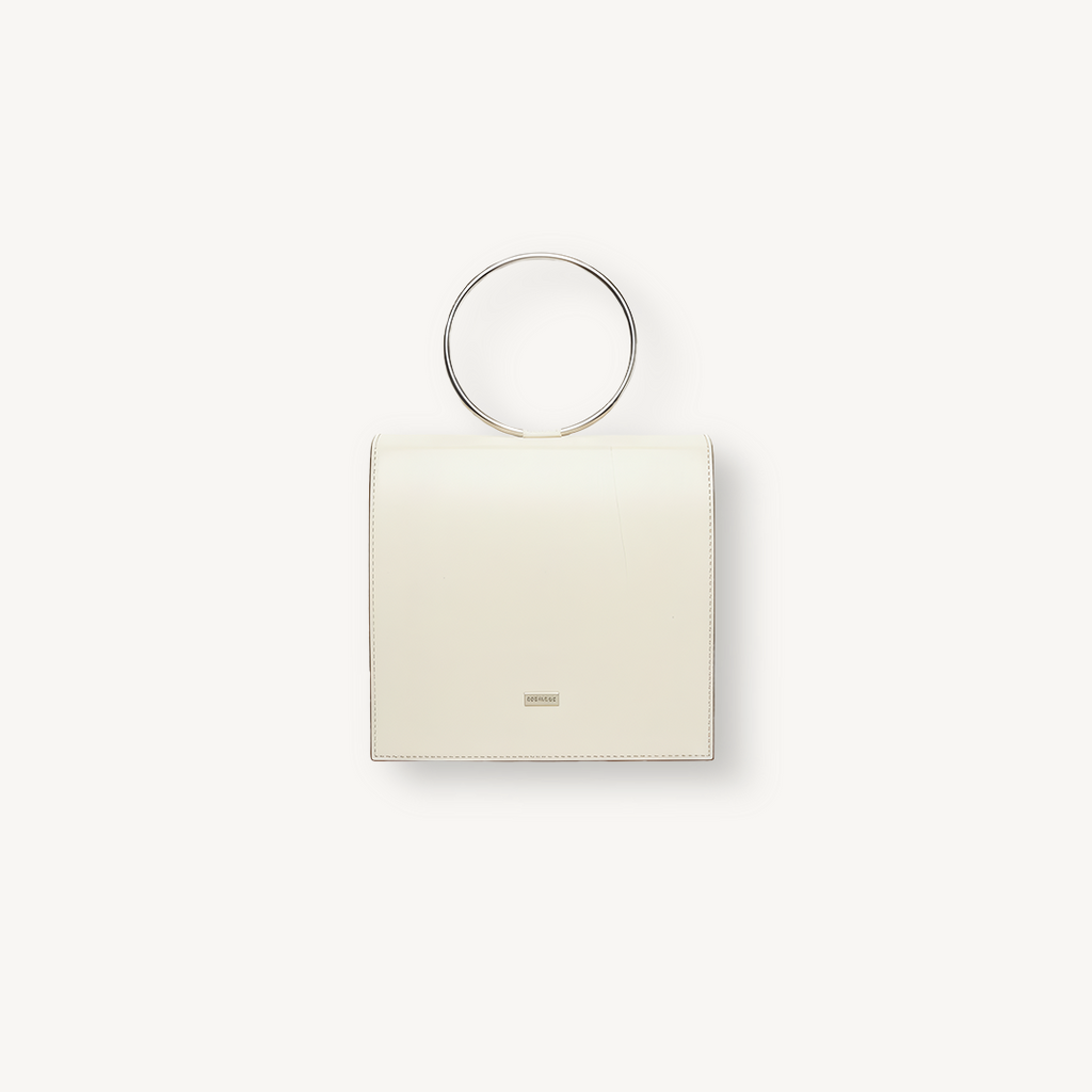 Beige handbag with circular handle on a white background