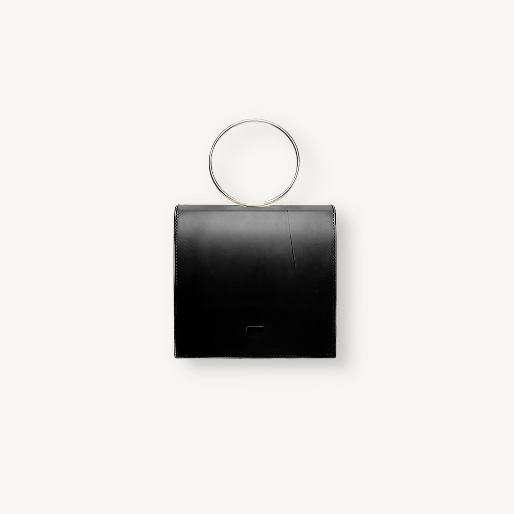 Black handbag with circular handle on a white background